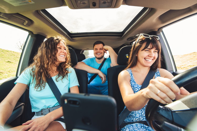 Friends on a road trip after they restructure vehicle finance to lower their monthly car repayments